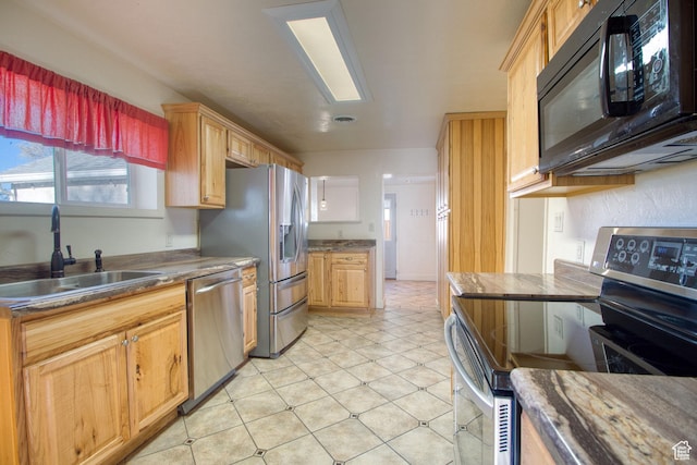 kitchen featuring visible vents, a sink, appliances with stainless steel finishes, and dark countertops