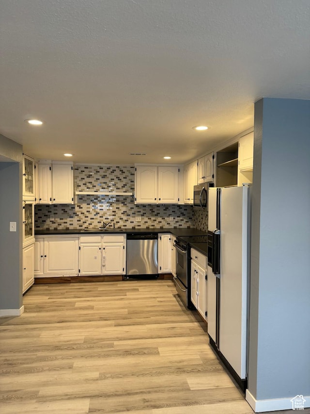 kitchen featuring white cabinetry, open shelves, appliances with stainless steel finishes, and dark countertops