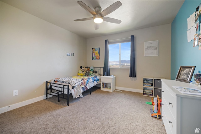 carpeted bedroom featuring baseboards and ceiling fan