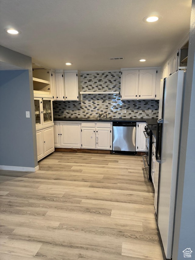 kitchen featuring freestanding refrigerator, white cabinets, visible vents, and dishwasher