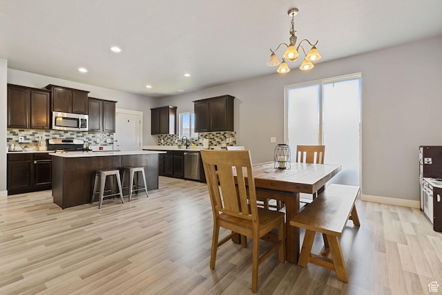 dining room featuring a healthy amount of sunlight, recessed lighting, light wood finished floors, and a chandelier