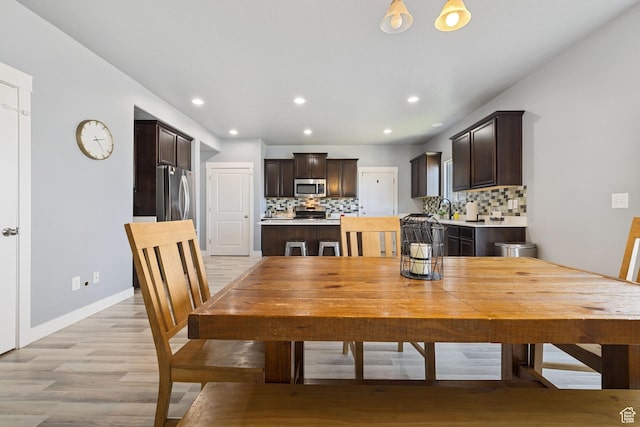 dining room featuring light wood-style floors, baseboards, and recessed lighting
