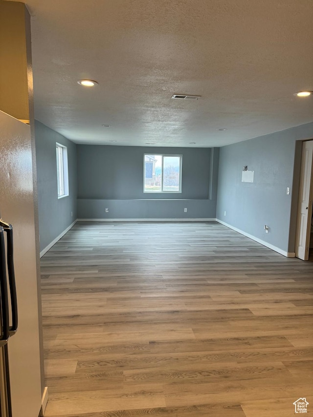 unfurnished room featuring recessed lighting, baseboards, visible vents, and wood finished floors