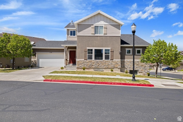 traditional home featuring concrete driveway, an attached garage, a shingled roof, stone siding, and stucco siding