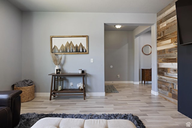 interior space featuring wooden walls, baseboards, and light wood-type flooring