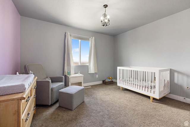 carpeted bedroom with baseboards and a chandelier