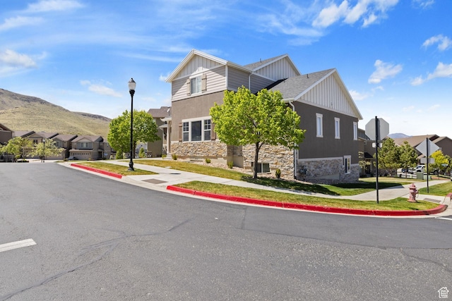 view of front of property with a residential view, a mountain view, board and batten siding, and stone siding