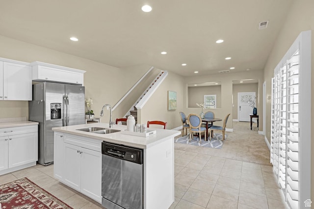kitchen with visible vents, light tile patterned flooring, light carpet, a sink, and appliances with stainless steel finishes
