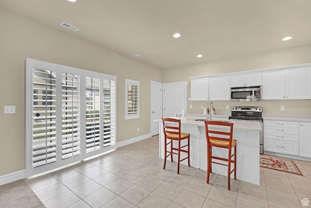 kitchen featuring visible vents, light countertops, stainless steel appliances, recessed lighting, and an island with sink