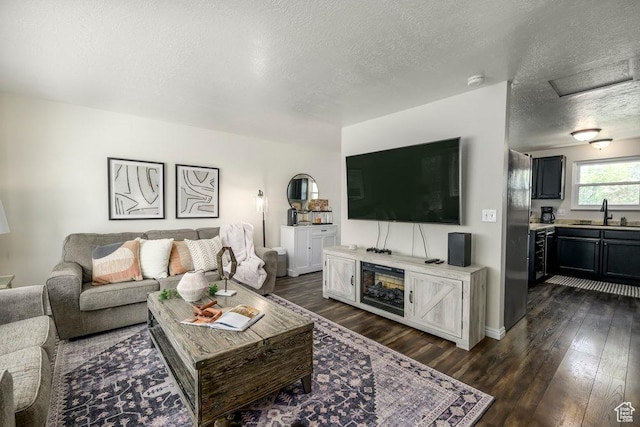 living room with a textured ceiling and dark wood-type flooring