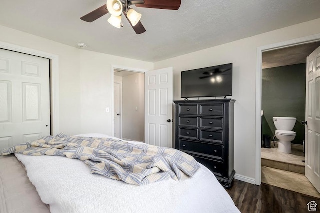 bedroom featuring baseboards, ceiling fan, dark wood-style flooring, and ensuite bath