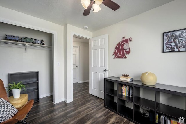 sitting room featuring baseboards, a ceiling fan, and dark wood-style floors