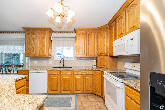 2983 W 2600 N, Plain City, UT 84404 - kitchen with brown cabinets, an inviting chandelier, a sink, white appliances, and tasteful backsplash