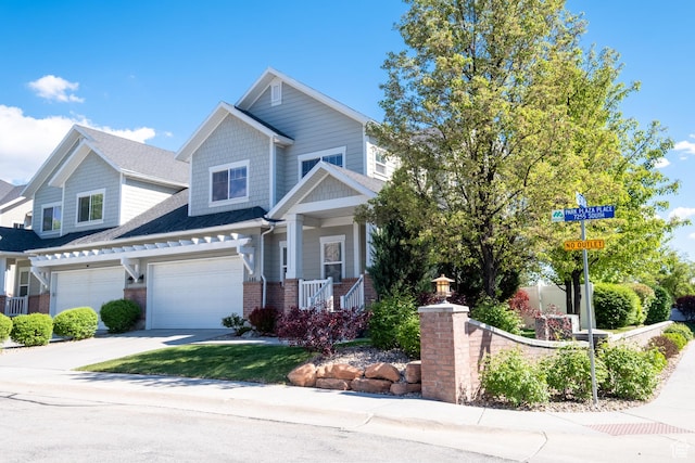 craftsman inspired home with brick siding, a garage, and concrete driveway