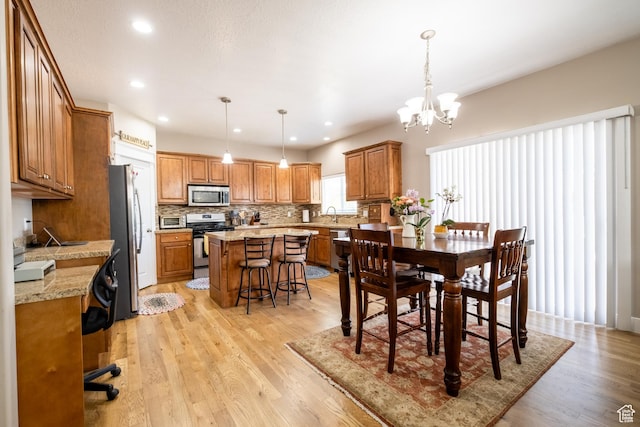 dining area featuring light wood finished floors, a chandelier, and recessed lighting