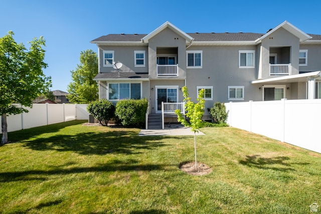 back of property with stucco siding and a balcony