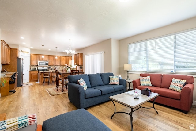 living room featuring light wood-type flooring, a chandelier, and recessed lighting