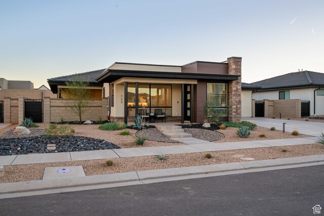 733 W Juniper Hill Dr, St George, UT 84790 - prairie-style home featuring a porch, fence, a gate, and a garage