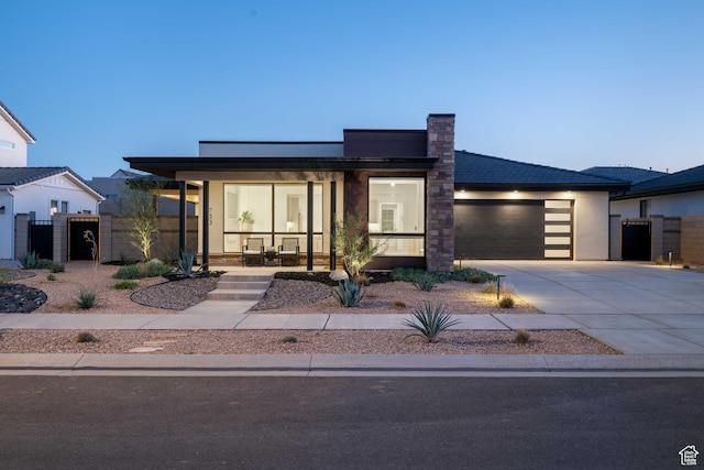 733 W Juniper Hill Dr, St George, UT 84790 - contemporary home featuring fence, an attached garage, a gate, covered porch, and driveway