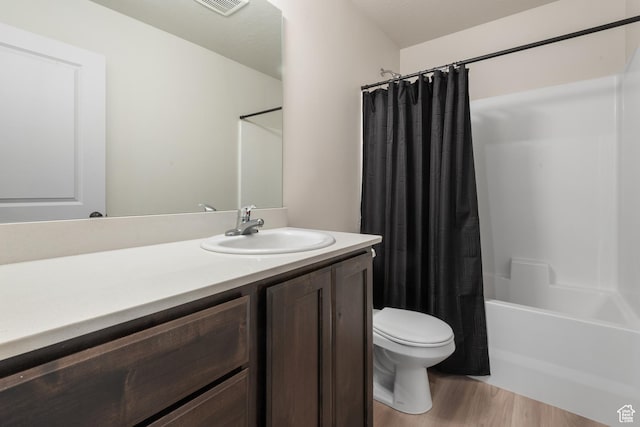 full bath featuring vanity, toilet, wood finished floors, and shower / tub combo with curtain