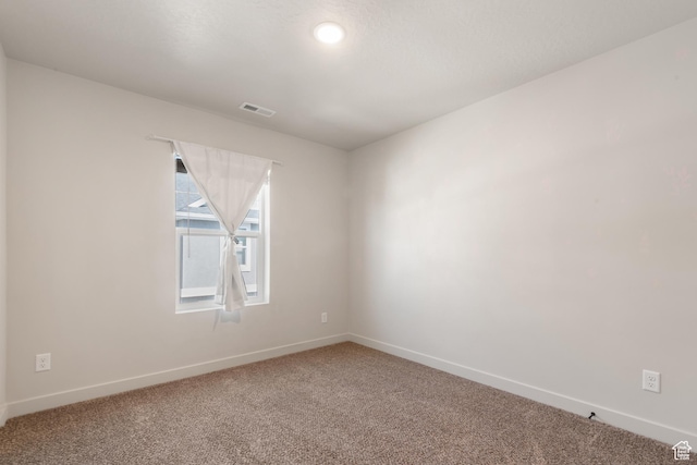carpeted spare room with baseboards and visible vents
