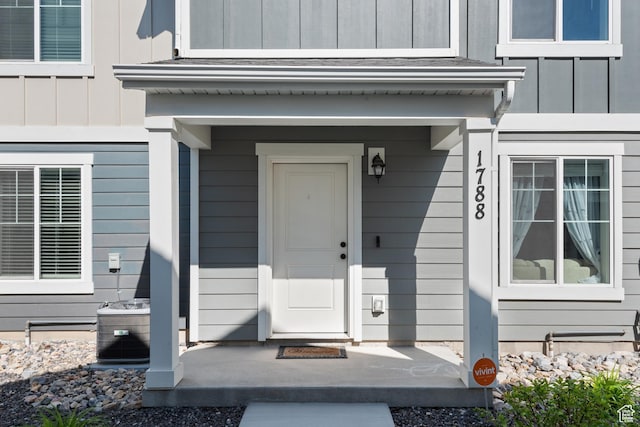 property entrance with board and batten siding and central air condition unit