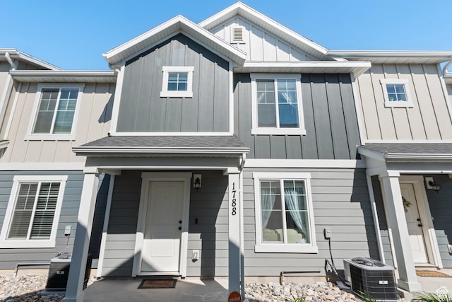 multi unit property with board and batten siding, central AC unit, and roof with shingles