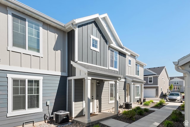 view of front facade with board and batten siding, central AC, and a residential view
