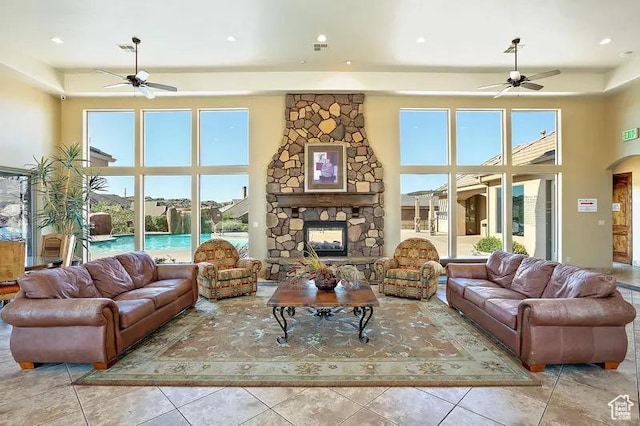 living room featuring ceiling fan, light tile patterned floors, and a towering ceiling