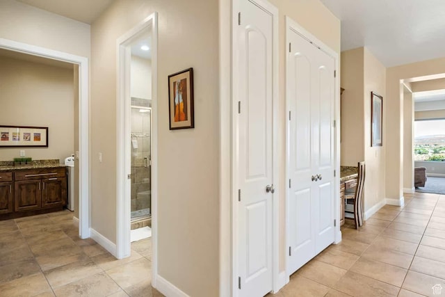 hallway featuring baseboards and light tile patterned floors