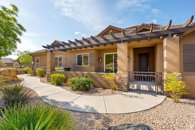 exterior space featuring a gate, stucco siding, and stone siding