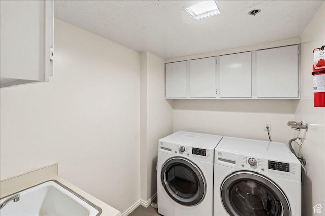 laundry room featuring a sink, baseboards, cabinet space, and washing machine and clothes dryer