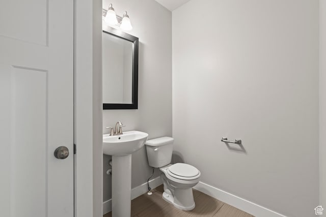 bathroom featuring baseboards, a sink, and toilet