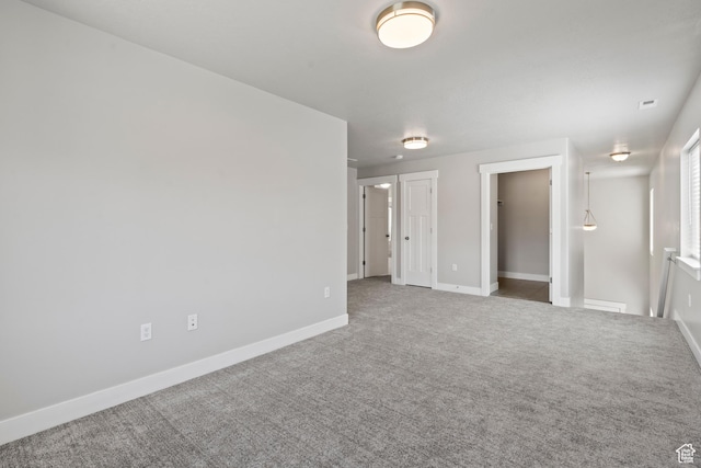 carpeted empty room with baseboards and visible vents