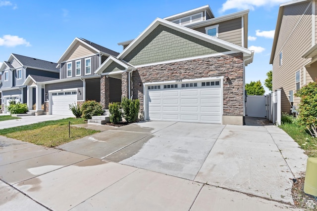 craftsman-style home featuring a gate, driveway, and stone siding