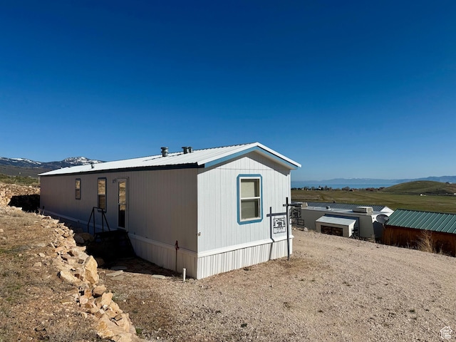 view of property exterior featuring metal roof and a mountain view