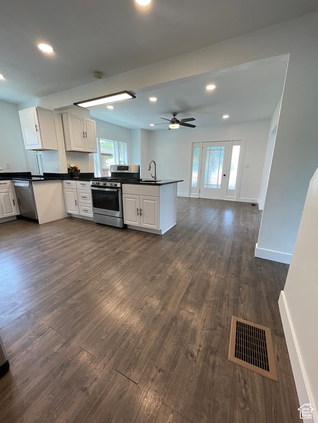 868 Washington Blvd, Ogden, UT 84404 - kitchen with dark wood-style flooring, stainless steel gas stove, visible vents, a peninsula, and dark countertops