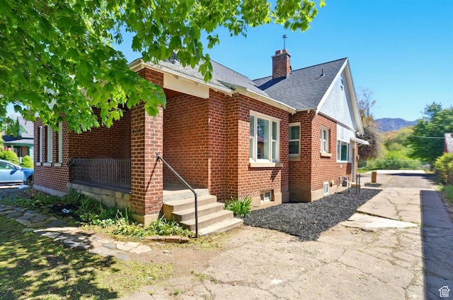 868 Washington Blvd, Ogden, UT 84404 - exterior space featuring brick siding, a chimney, a mountain view, and roof with shingles