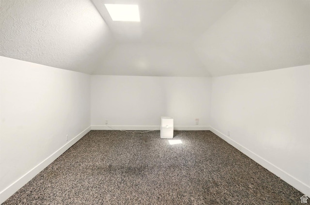 868 Washington Blvd, Ogden, UT 84404 - additional living space with dark colored carpet, baseboards, and vaulted ceiling