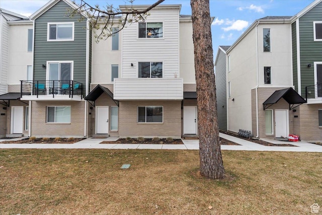 townhome / multi-family property with a front yard