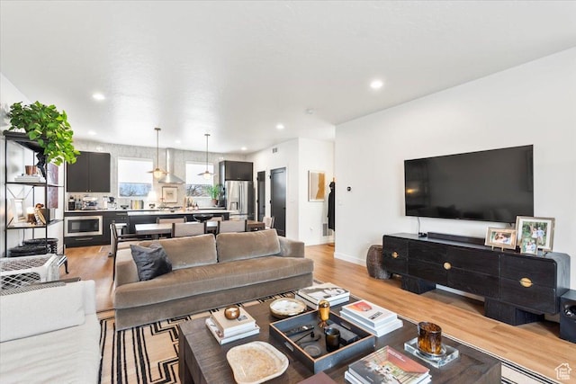 living area with light wood-type flooring, recessed lighting, baseboards, and visible vents