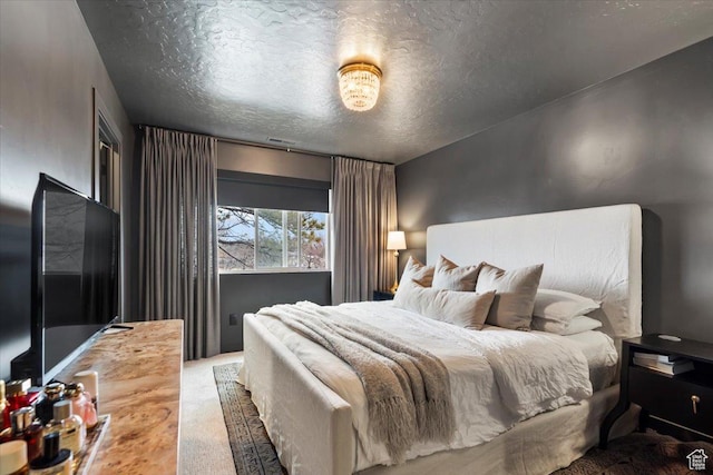 bedroom with carpet floors and a textured ceiling