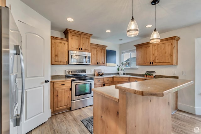 8983 N Barton Creek Dr, Eagle Mountain, UT 84005 - kitchen featuring light wood-style floors, recessed lighting, hanging light fixtures, and stainless steel appliances