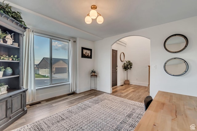 8983 N Barton Creek Dr, Eagle Mountain, UT 84005 - interior space with light wood-type flooring, arched walkways, baseboards, and visible vents