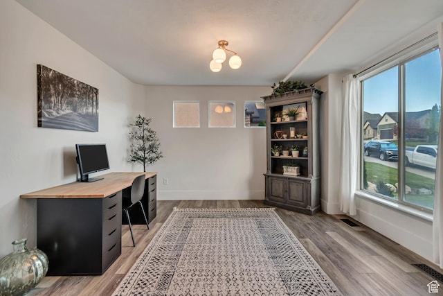 8983 N Barton Creek Dr, Eagle Mountain, UT 84005 - office space with baseboards, visible vents, light wood-type flooring, and a notable chandelier