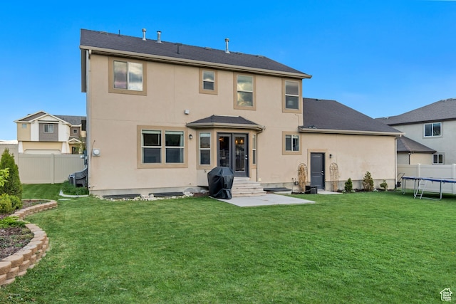 8983 N Barton Creek Dr, Eagle Mountain, UT 84005 - back of property with fence, a trampoline, and stucco siding