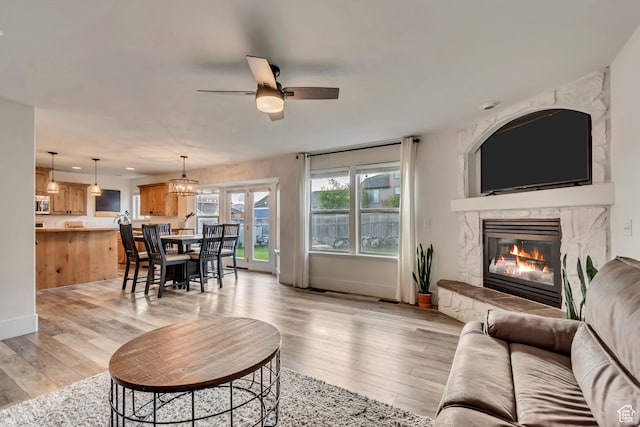 8983 N Barton Creek Dr, Eagle Mountain, UT 84005 - living room with baseboards, light wood-style flooring, ceiling fan, and a premium fireplace