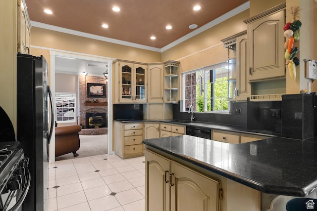 kitchen with cream cabinets, dark countertops, freestanding refrigerator, a peninsula, and recessed lighting