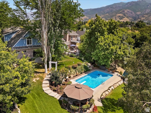 outdoor pool with a yard, a diving board, and a mountain view
