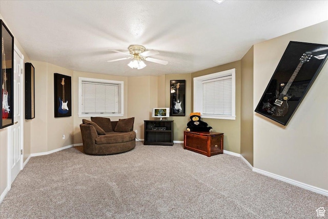 sitting room with baseboards, carpet flooring, and ceiling fan